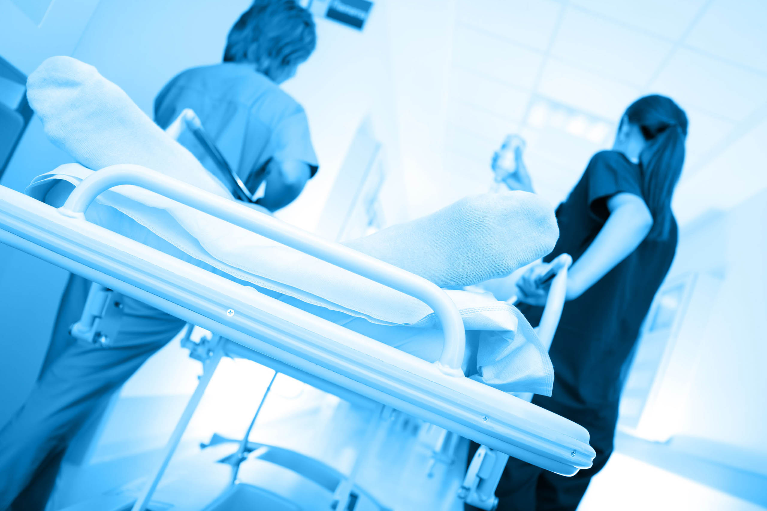 32597945 - patient on the bed being taken along the corridor in the hospital Medical facility cleaning services to HIPAA standards