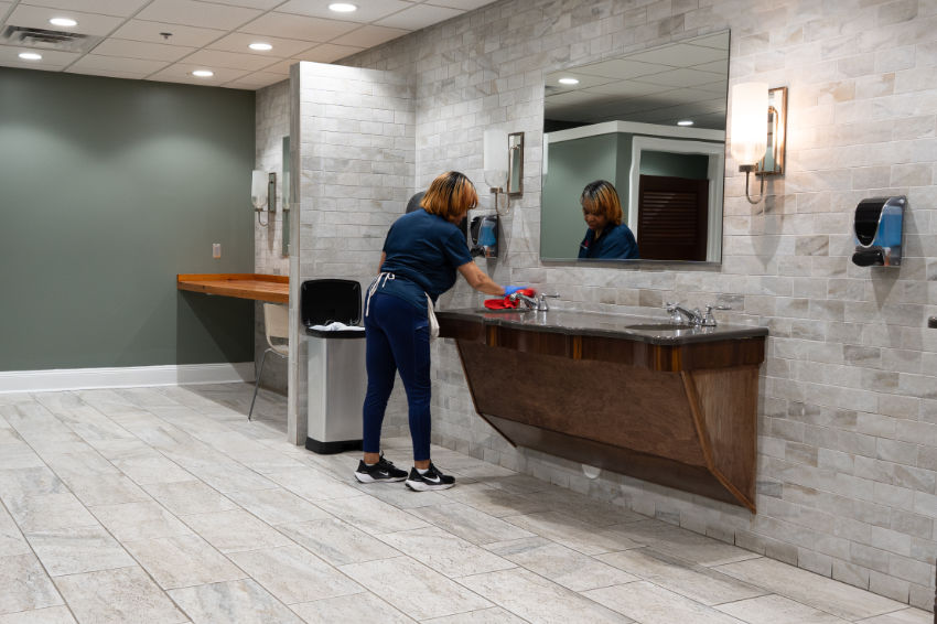 CST team member cleaning a bathroom at Revolution Mill